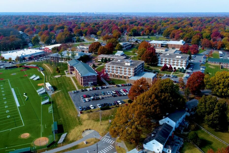A drone photograph of the Avila University campus showing a number of buildings, trees, and a football field.